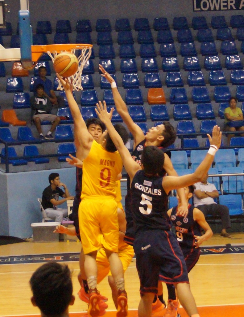 Jasper Magno ekes out a lay-up disregarding the pressure of the three squires.
